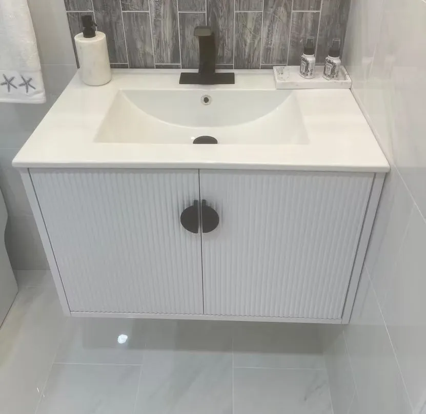 Wall hung fluted vanity with a matte black faucet